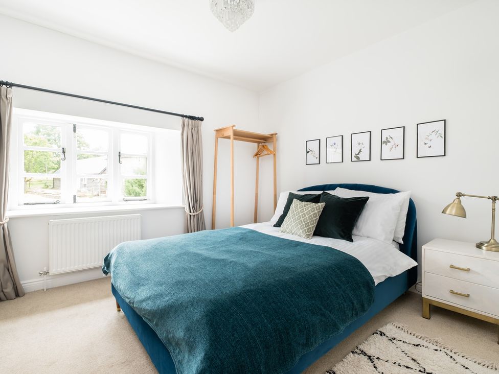 A bedroom with a bed and a hanging rack at Henhouse Farm Bodenham