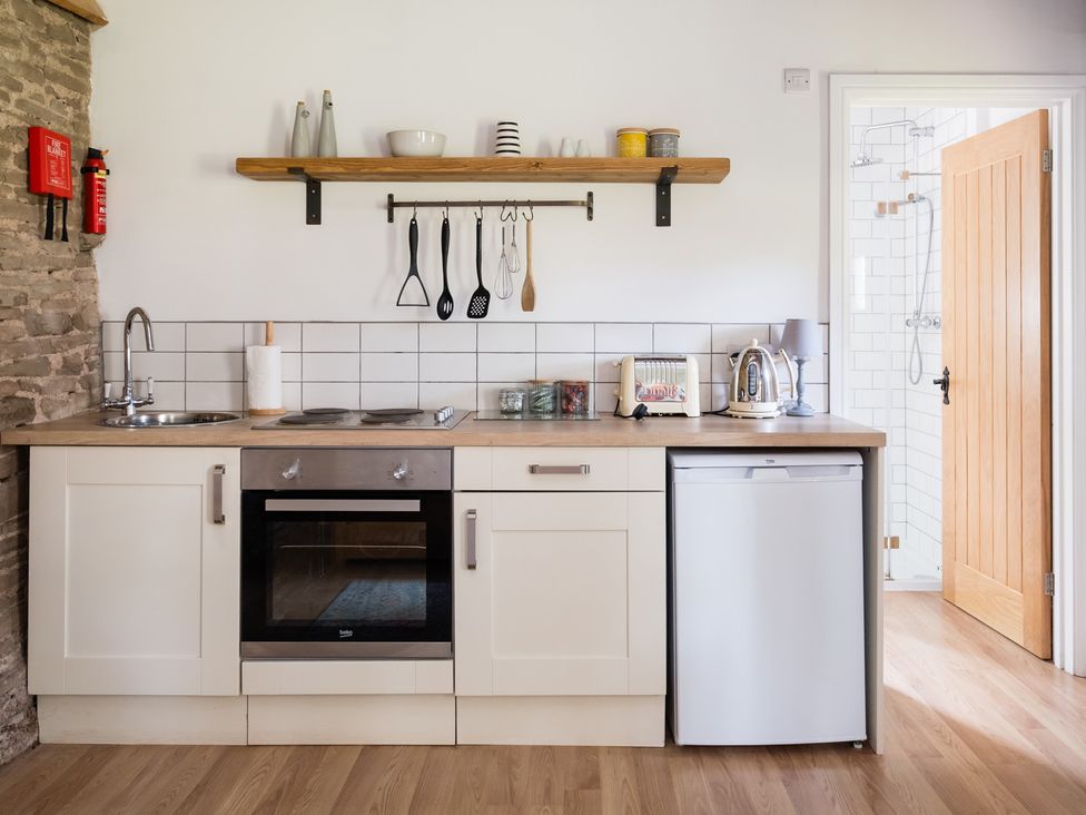 A kitchen with a sink, stove and refrigerator at Henhouse Farm in Bodenham
