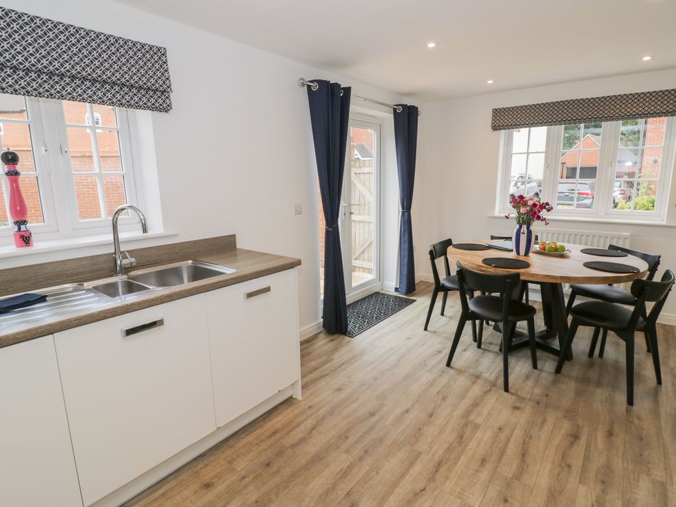 A kitchen with a dining table and sink at Silverstone Paddock Retreat in Silverstone