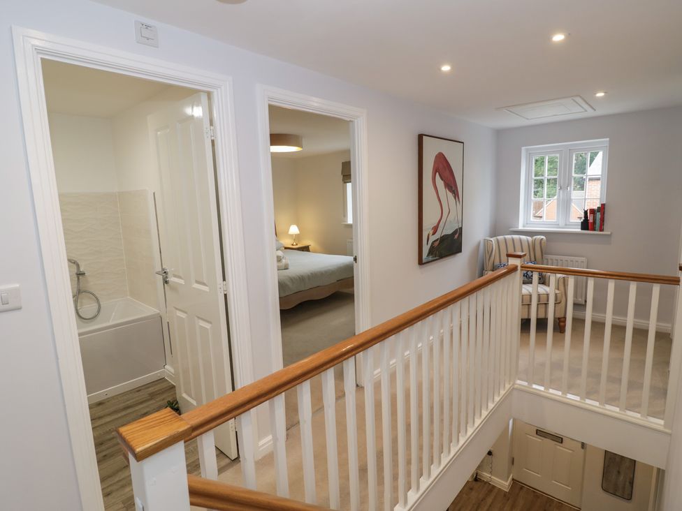 A hallway with doors to a bathroom and bedroom at Silverstone Paddock Retreat in Silverstone