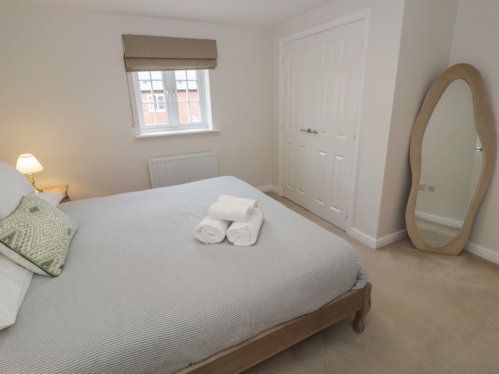 A bedroom with a bed and towels at Silverstone Paddock Retreat in Silverstone