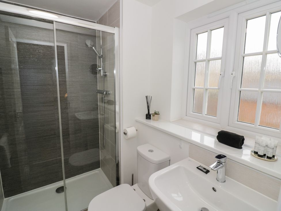 A bathroom with a shower, toilet, and sink at Silverstone Paddock Retreat in Silverstone