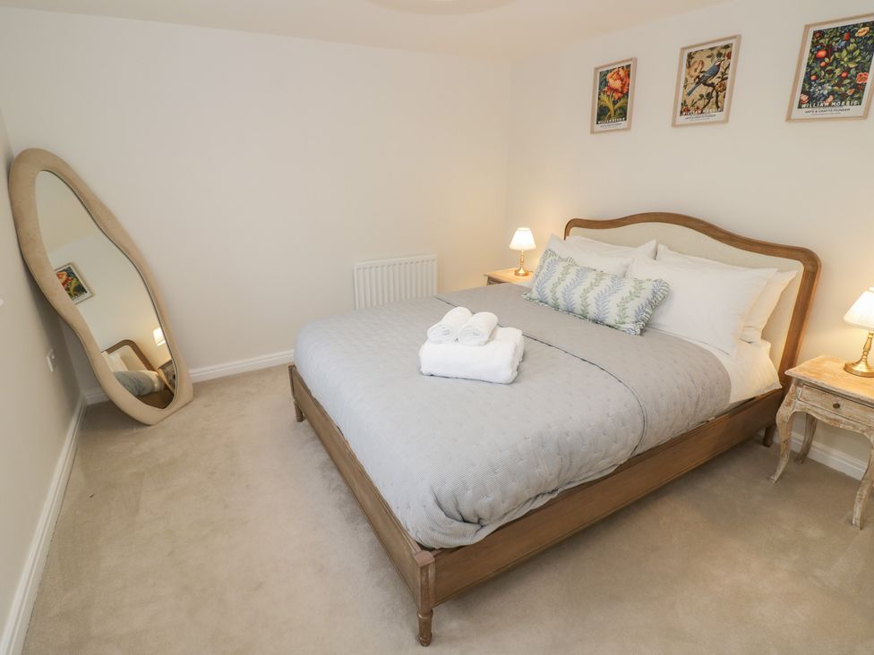 A bedroom with a bed and a mirror at Silverstone Paddock Retreat in Silverstone