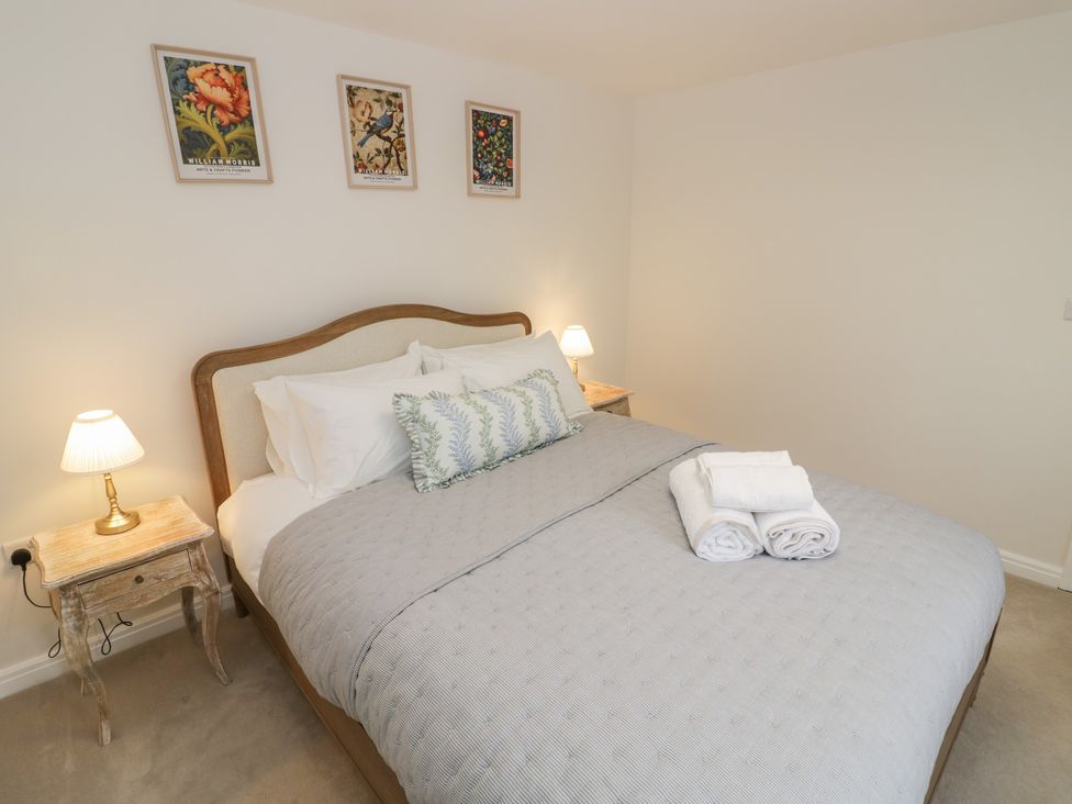 A bedroom with a bed and wall art at Silverstone Paddock Retreat in Silverstone