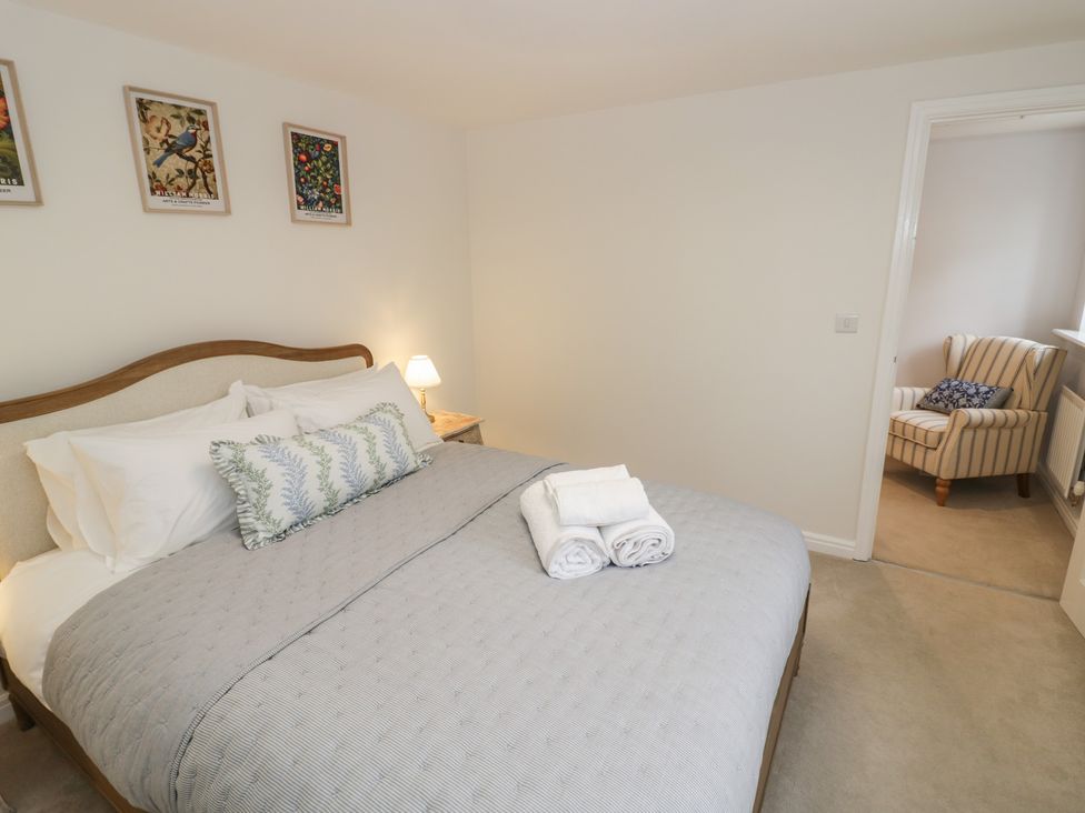 A bedroom with a bed and a chair at Silverstone Paddock Retreat in Silverstone