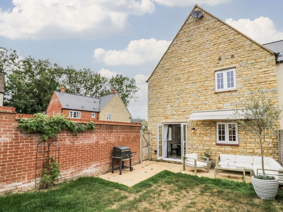 A garden with a grill and seating area at Silverstone Paddock Retreat in Silverstone