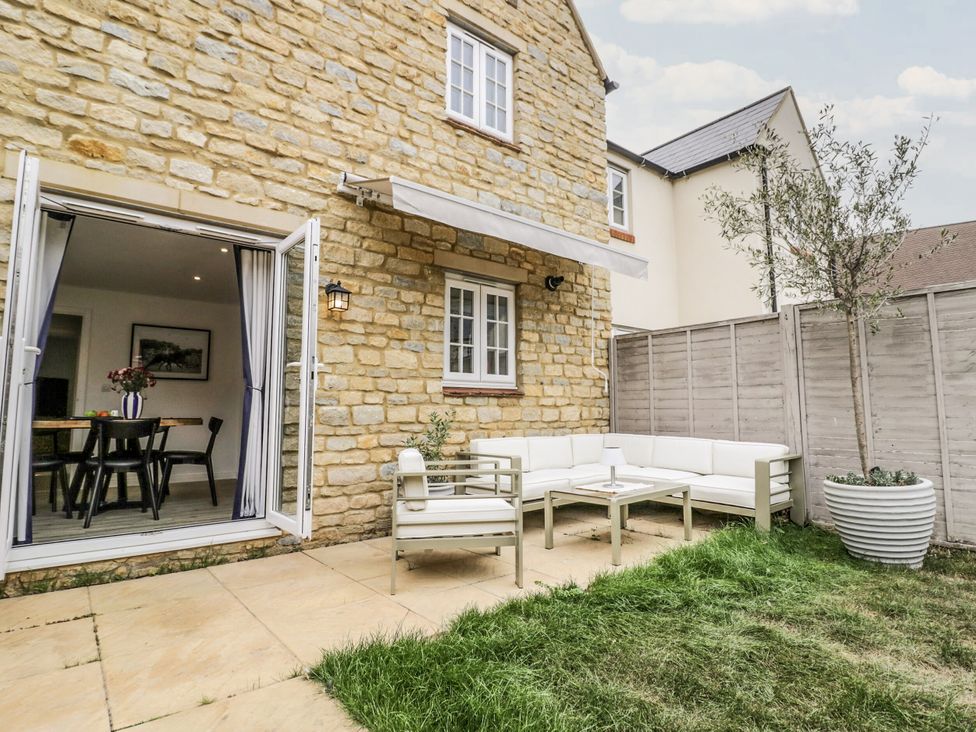 An outdoor seating area with a sofa and table at Silverstone Paddock Retreat in Silverstone