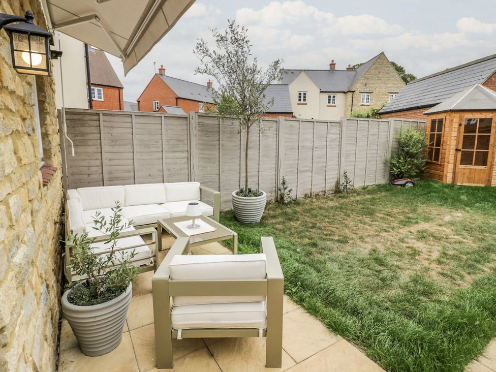 An outdoor seating area with a sofa and table at Silverstone Paddock Retreat in Silverstone
