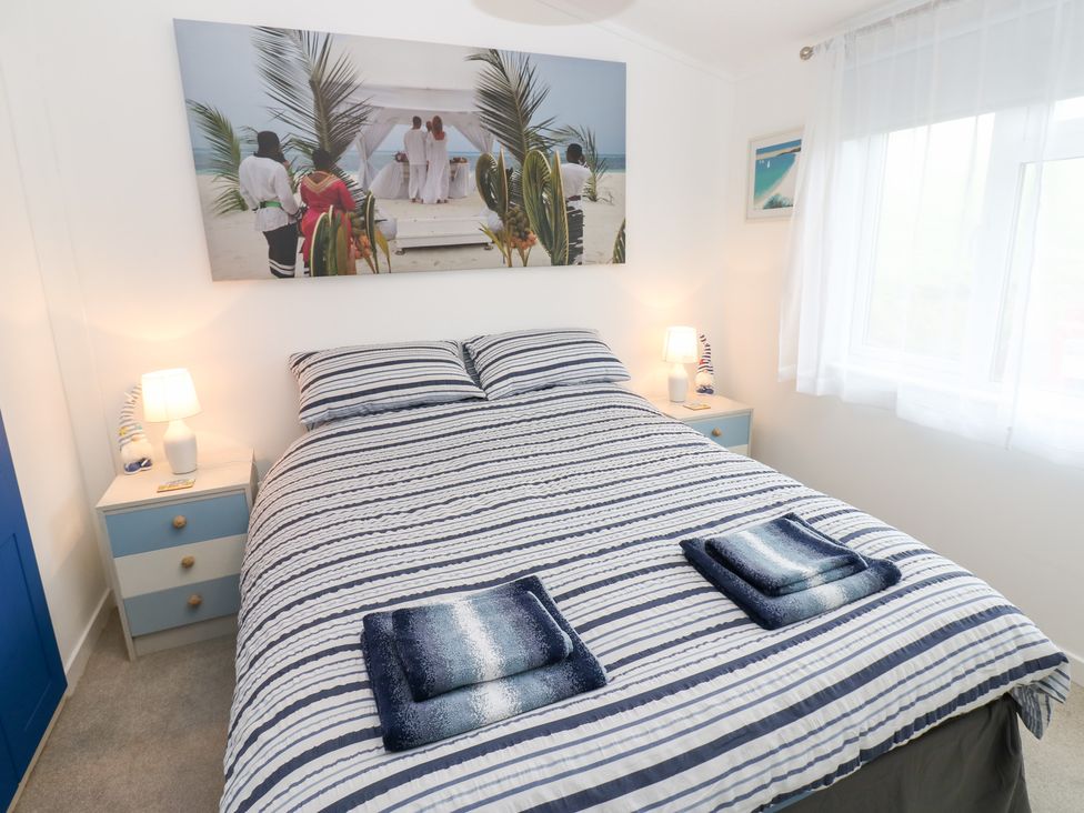 A bedroom with a bed and nightstand at The Sanctuary Badgers Retreat Holiday Park near Catterick Garrison, North Yorkshire