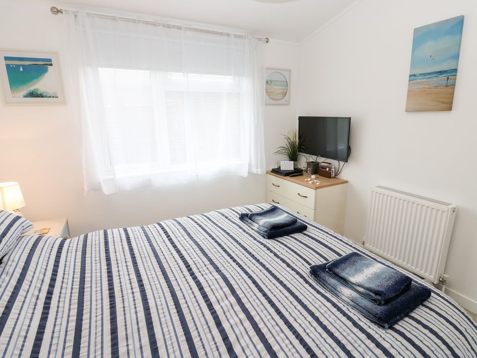 A bedroom with a bed and television at The Sanctuary Badgers Retreat Holiday Park near Catterick Garrison North Yorkshire