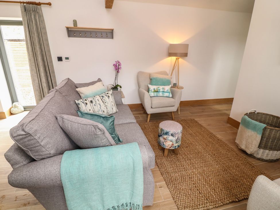 A living room with a sofa and armchair at Tawny Barn in Woodhall Spa