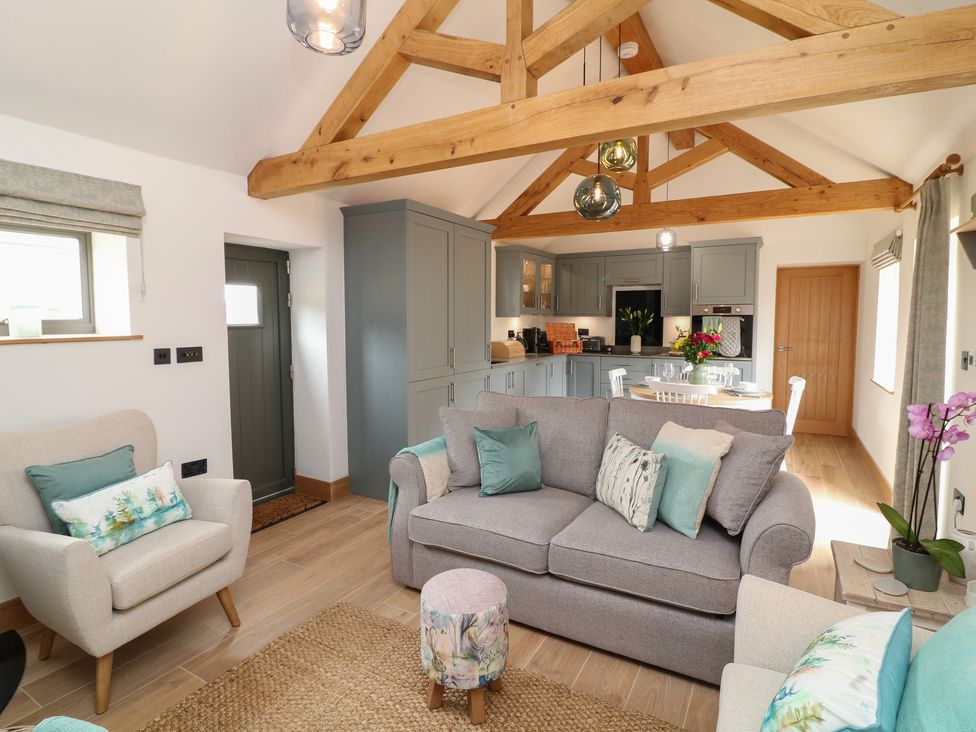 A living room with a sofa and dining area at Tawny Barn in Woodhall Spa