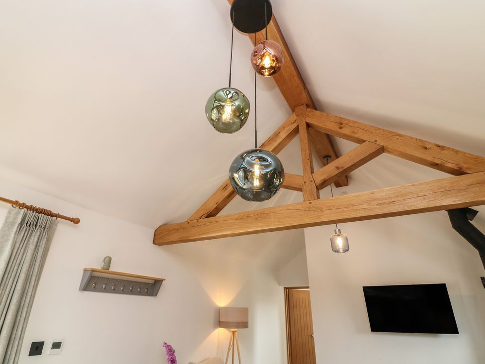 A living room with pendant lights and wooden beams at Tawny Barn in Woodhall Spa