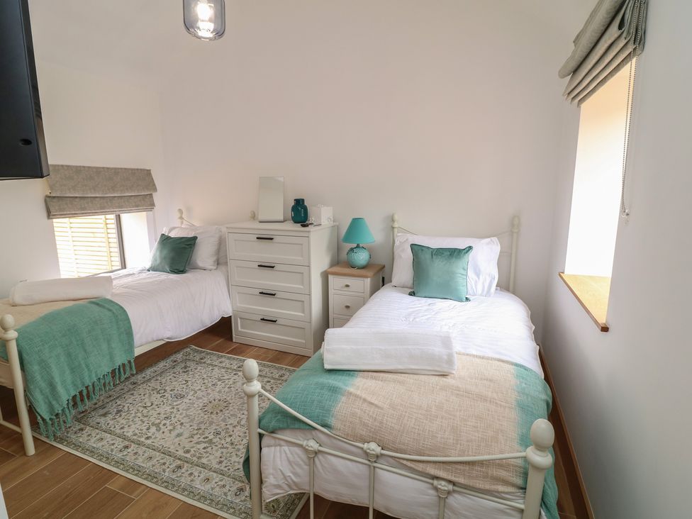 A bedroom with two beds and a window at Tawny Barn in Woodhall Spa