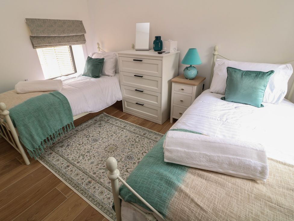 A bedroom with two twin beds and a dresser at Tawny Barn in Woodhall Spa