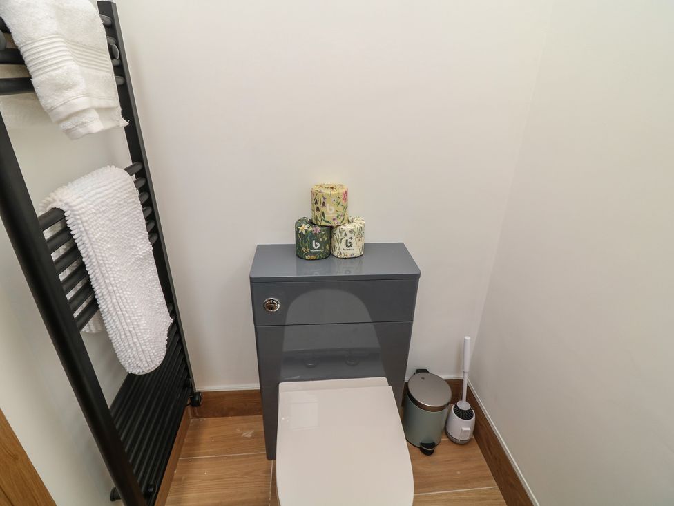 A bathroom with a toilet and storage cabinet at Tawny Barn in Woodhall Spa
