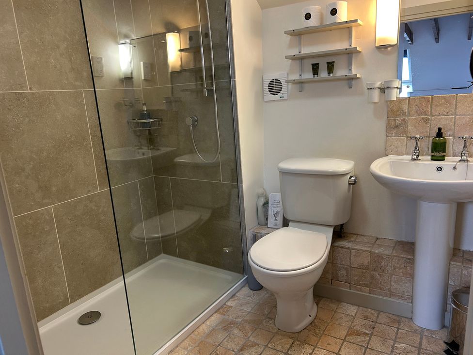 A bathroom with a shower, toilet, and sink at Tom's Barn in Parwich
