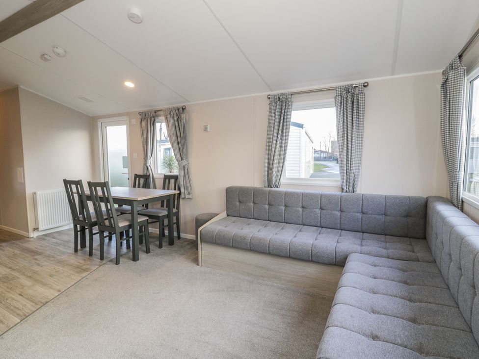 A living room with a dining table and chairs at Lido Gold 120 in Prestatyn