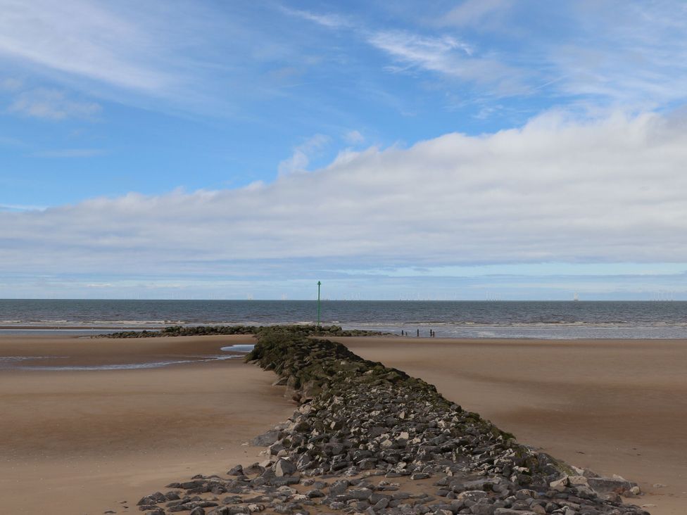 A beach with a rock formation and sea at Lido Gold 120 in Prestatyn