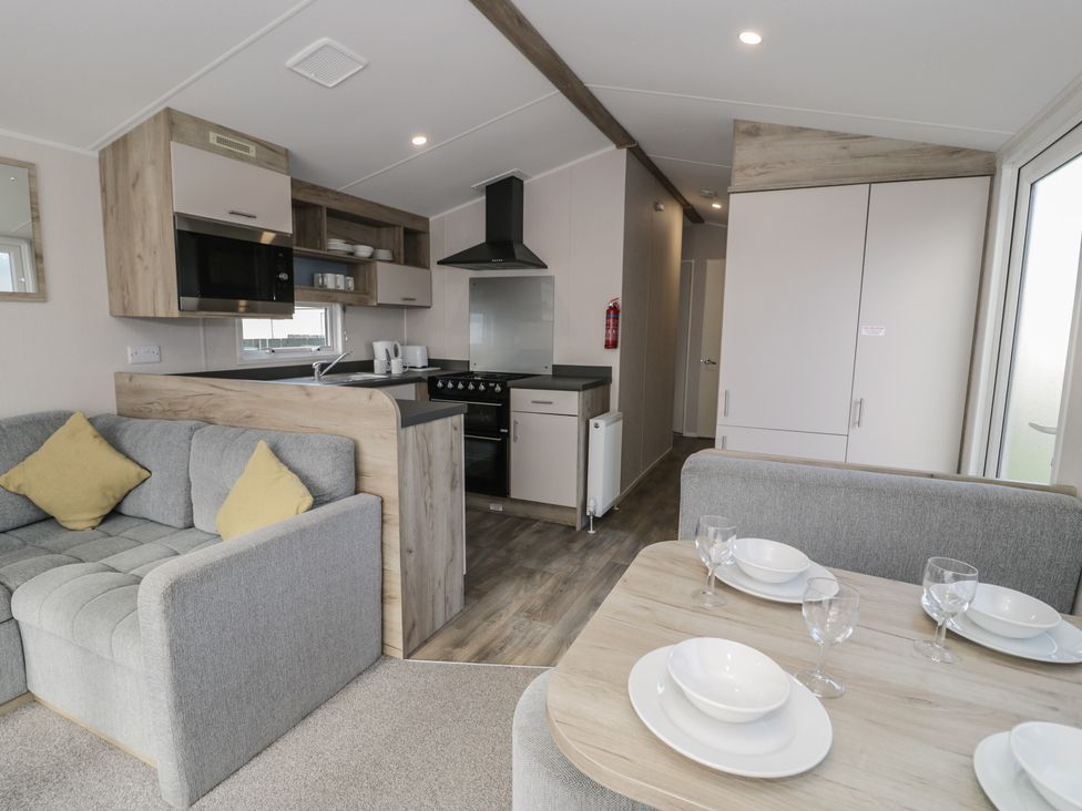 A kitchen with a sofa and dining table at Lido Gold 273 Prestatyn