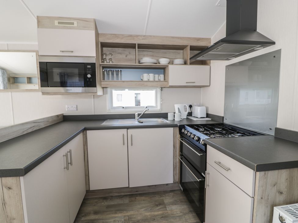A kitchen with cabinets and appliances at Lido Gold 273 Prestatyn