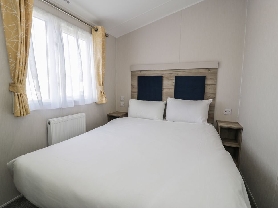 A bedroom with a bed and curtains at Lido Gold 273 in Prestatyn