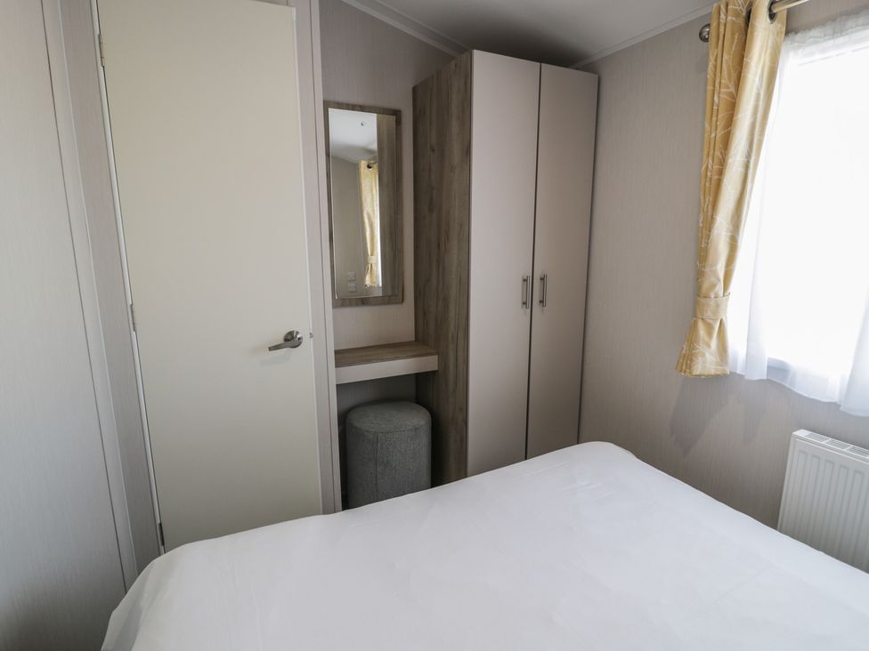 A bedroom with a bed and dressing area at Lido Gold 273 Prestatyn