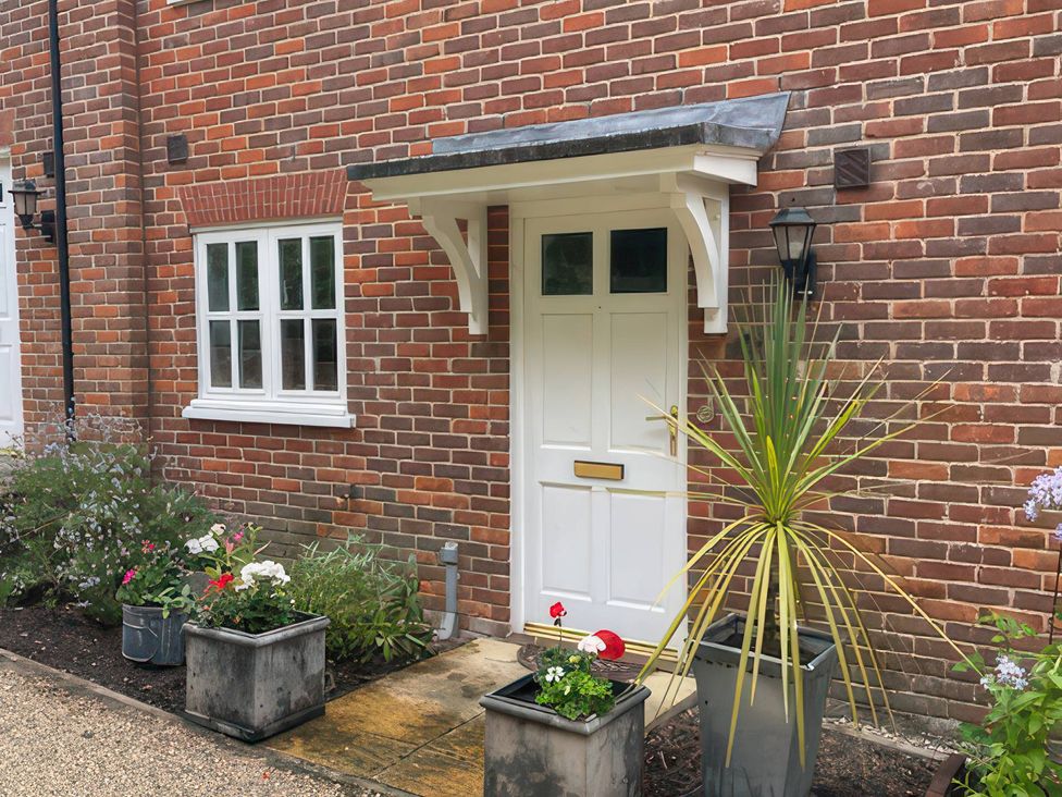 A front door with planters and flowers at Bay Tree Cottage, Peasenhall