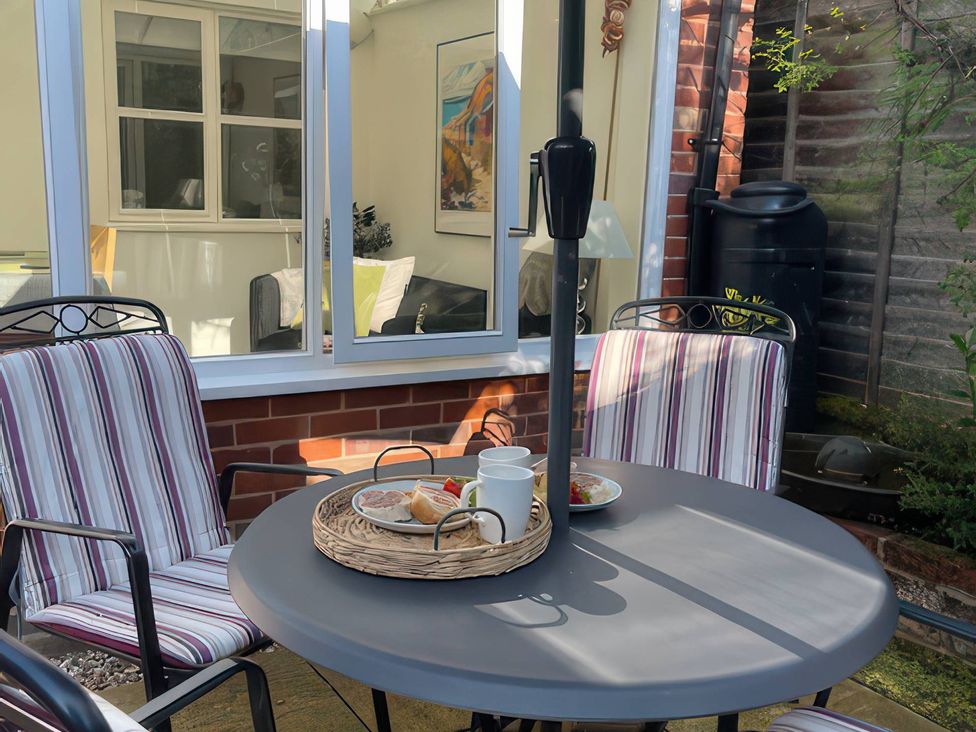A garden with a table and chairs at Bay Tree Cottage, Peasenhall