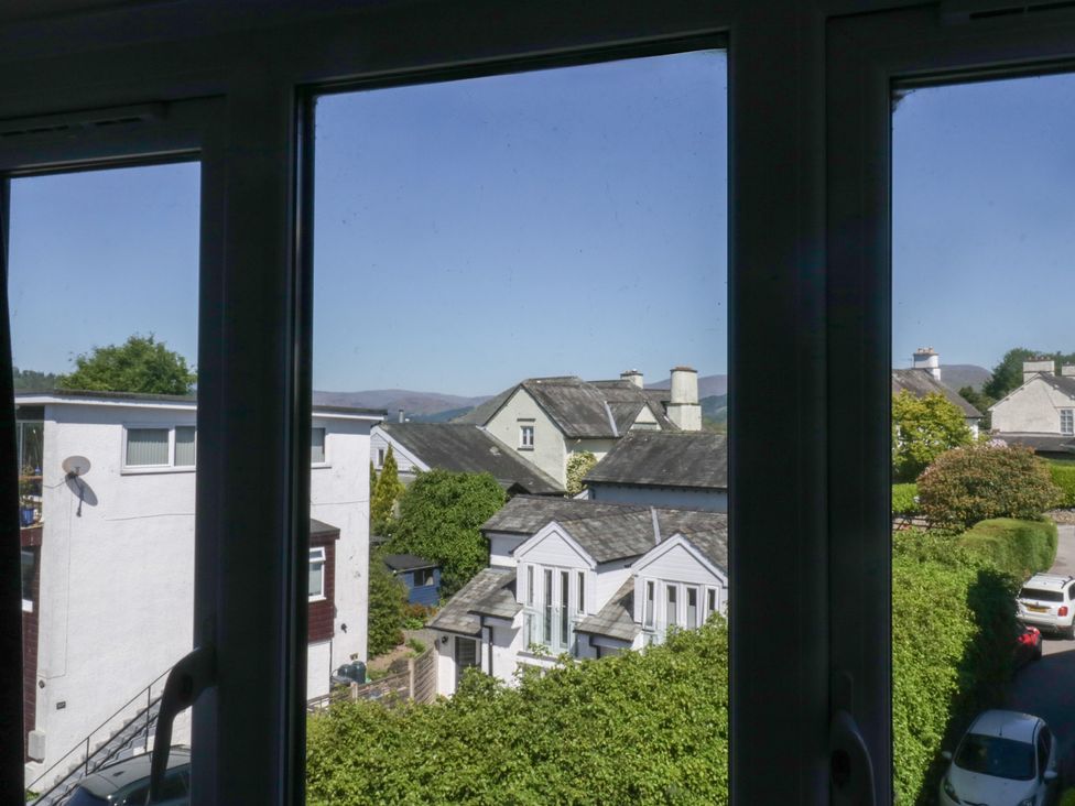 A view of houses and greenery seen through a window at Eves Attic in Bowness-On-Windermere