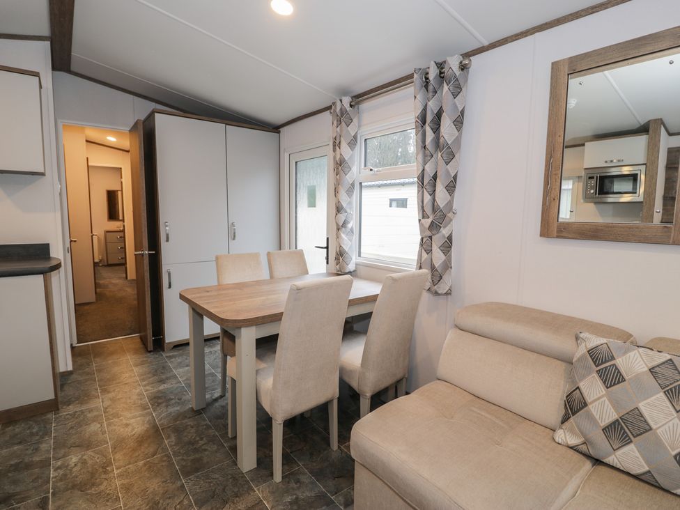 A dining area with a table and chairs at Woodlands Gold (WO40) in Ruthin