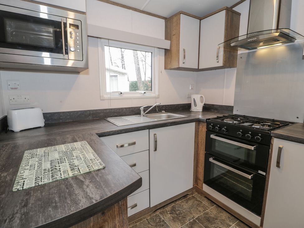 A kitchen with sink, oven, and countertop at Woodlands Gold (WO40) Ruthin