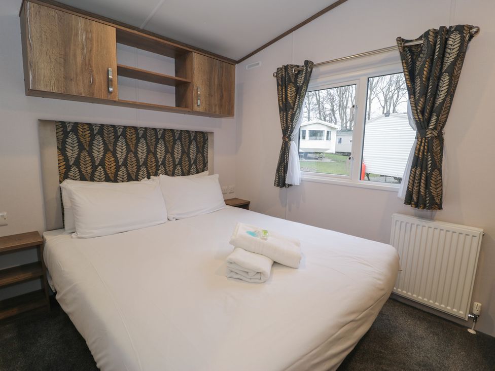 A bedroom featuring a double bed and window at Woodlands Gold (WO40) in Ruthin