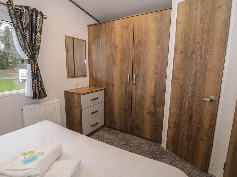 A bedroom with a wardrobe and mirror at Woodlands Gold (WO40) in Ruthin