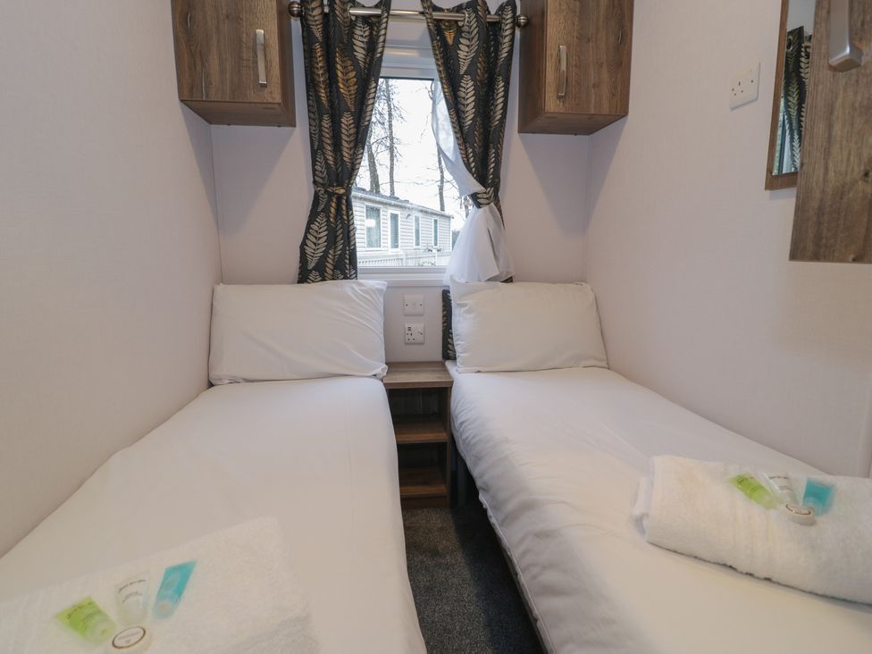A bedroom with two single beds and a window at Woodlands Gold (WO40) in Ruthin