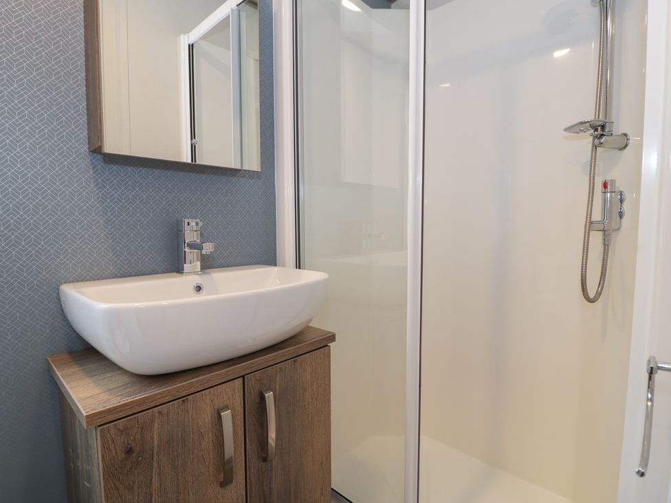 A bathroom with a wash basin and shower at Woodlands Gold (WO40) in Ruthin