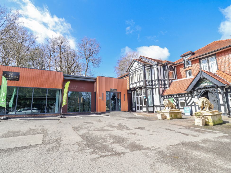 An entrance area with building and lion statues at Woodlands Gold in Ruthin