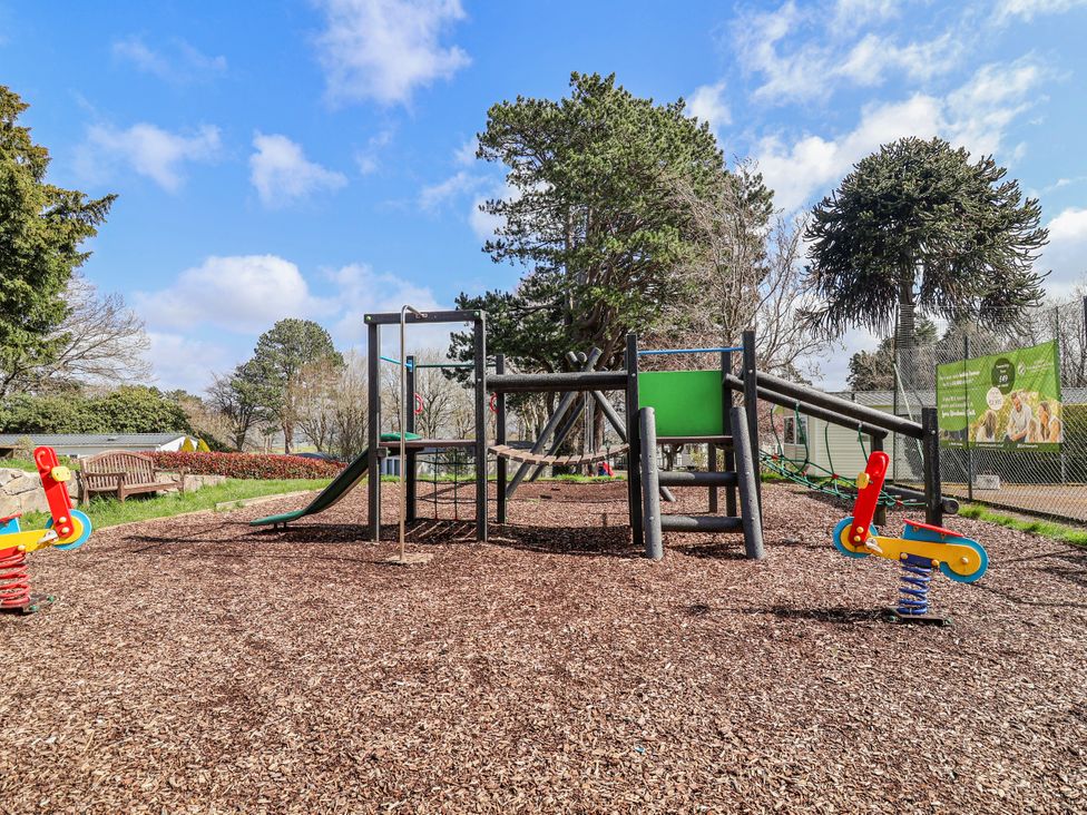 A playground with a climbing frame and slide at Woodlands Gold (WO40) in Ruthin