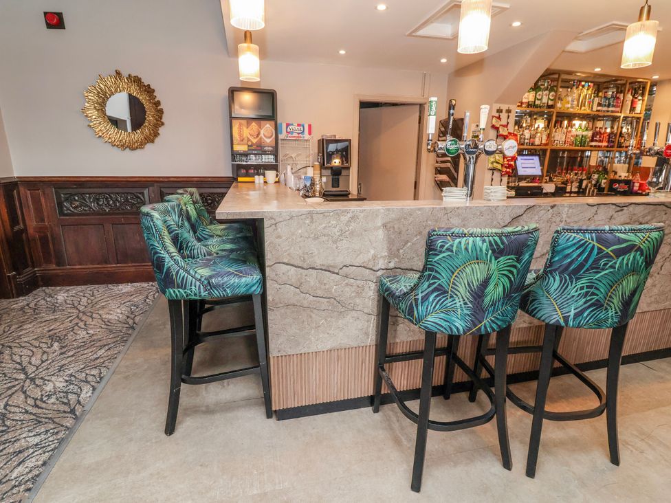 A bar area with stools and a counter at Woodlands Gold (WO40) in Ruthin