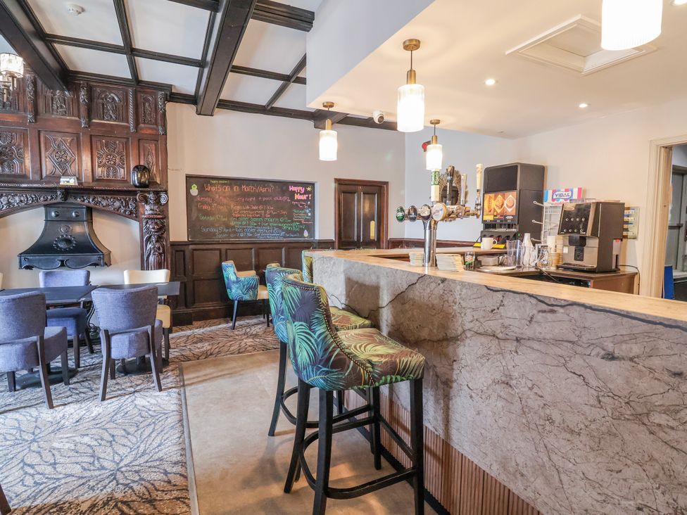 A bar area with seating and a fireplace at Woodlands Gold (WO40) in Ruthin