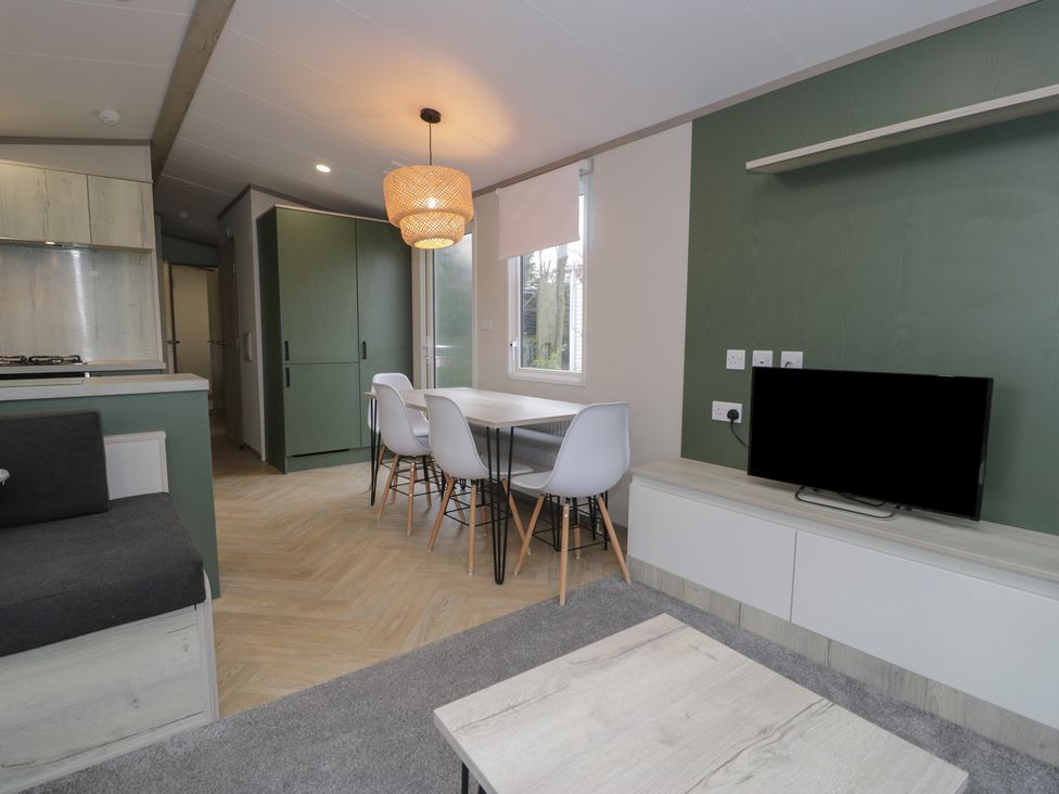 A dining room with a table and chairs at Woodlands Gold (WO06) in Ruthin