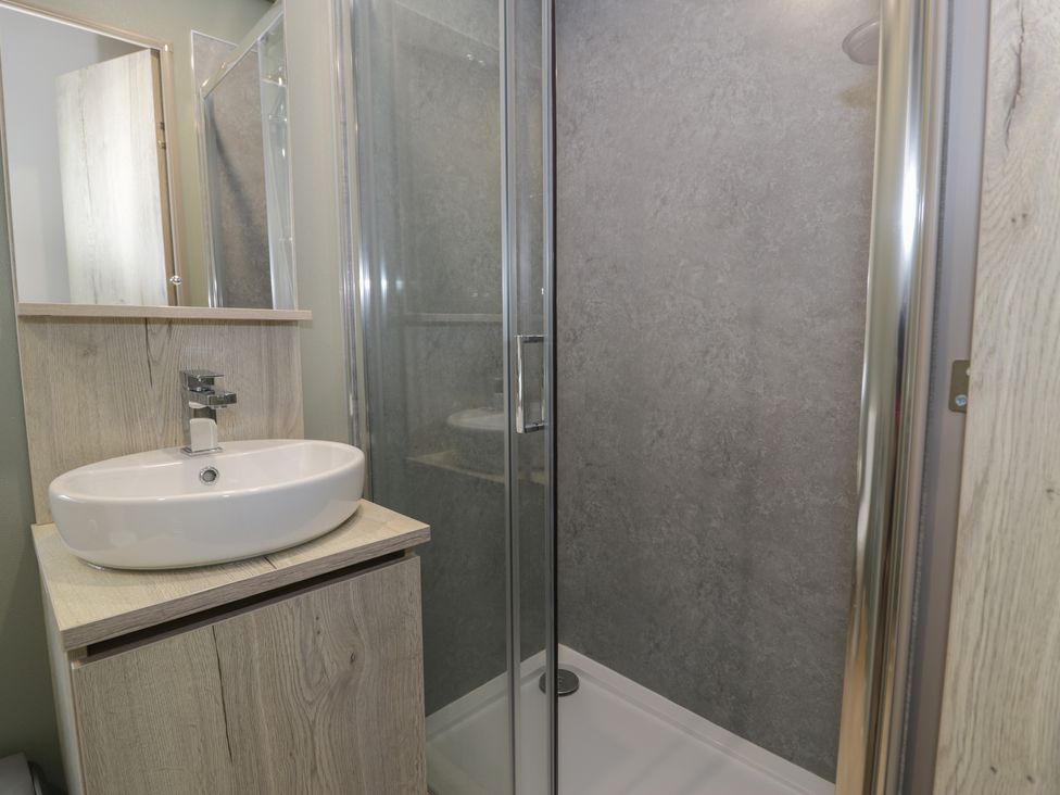 A bathroom with a sink and shower at Woodlands Gold (WO06) Ruthin