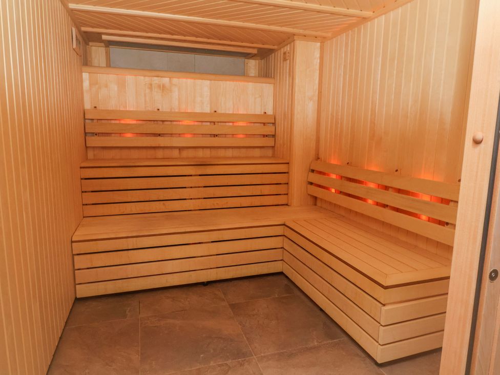 A sauna with wooden benches and interior lighting at Woodlands Gold (WO06) in Ruthin