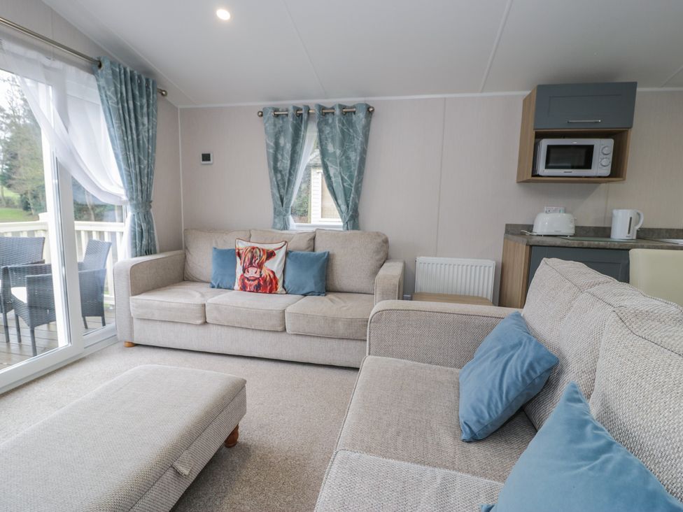 A living room with a sofa and a microwave at Woodlands Platinum (WO29) in Ruthin