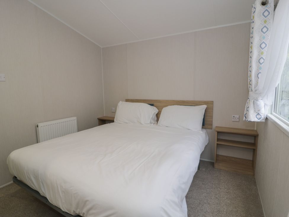 A bedroom with a bed and bedside table at Woodlands Platinum (WO29) in Ruthin