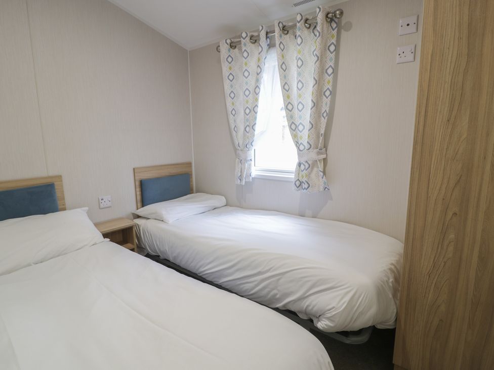 A bedroom with two beds and a window at Woodlands Platinum (WO29) in Ruthin