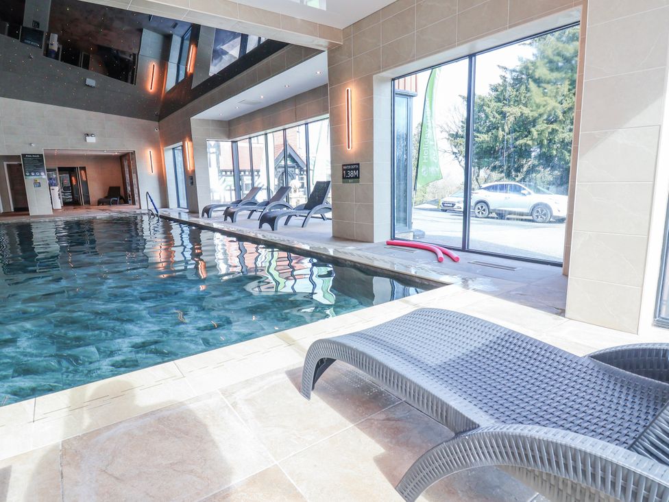 An indoor swimming pool with lounge chairs at Woodlands Platinum (WO29) Ruthin