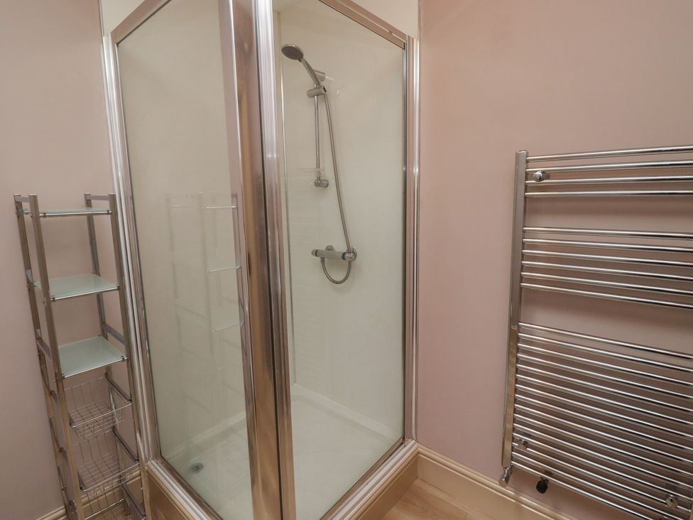A shower with a towel rail and shelf unit at Annex in Morpeth
