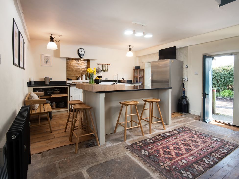 A kitchen with a fridge and counter at The Old Coach House in Eglingham near Alnwick