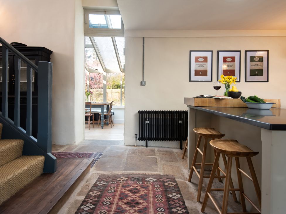 A kitchen with bar stools and a dining area at The Old Coach House Eglingham near Alnwick